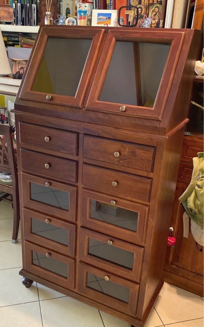 Dettaglio mobile dispensa noce scuro con cassetti e ante in vetro, design classico.